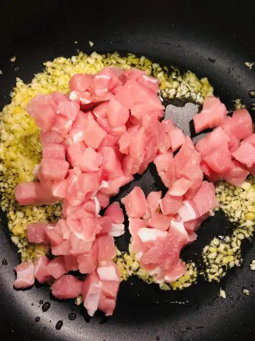 minced garlic, ginger, and diced pork in a pan