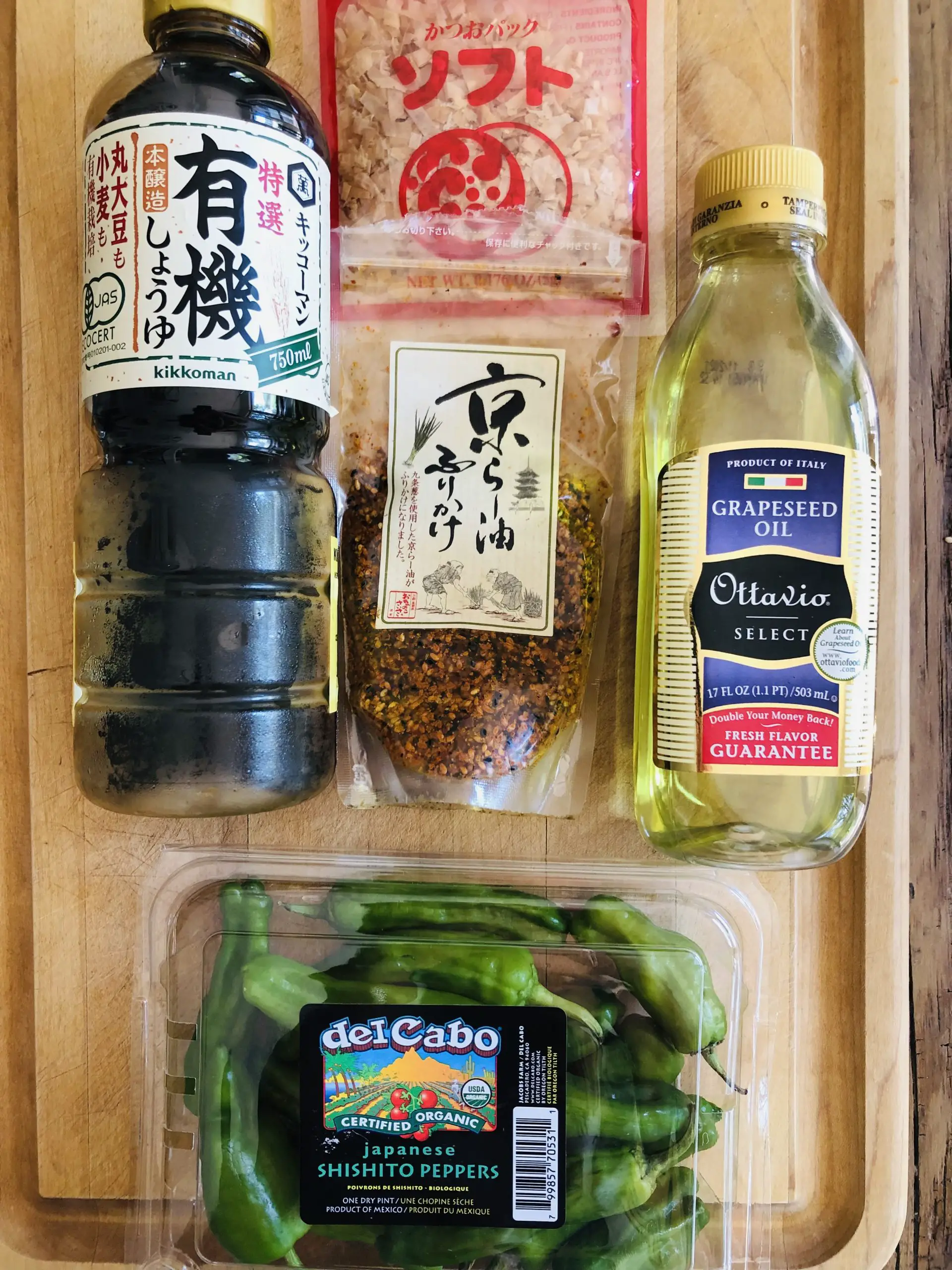 Package of shishito peppers, bottle of soy sauce and grapeseed oil, pack of bonito flakes and pack of furikake.