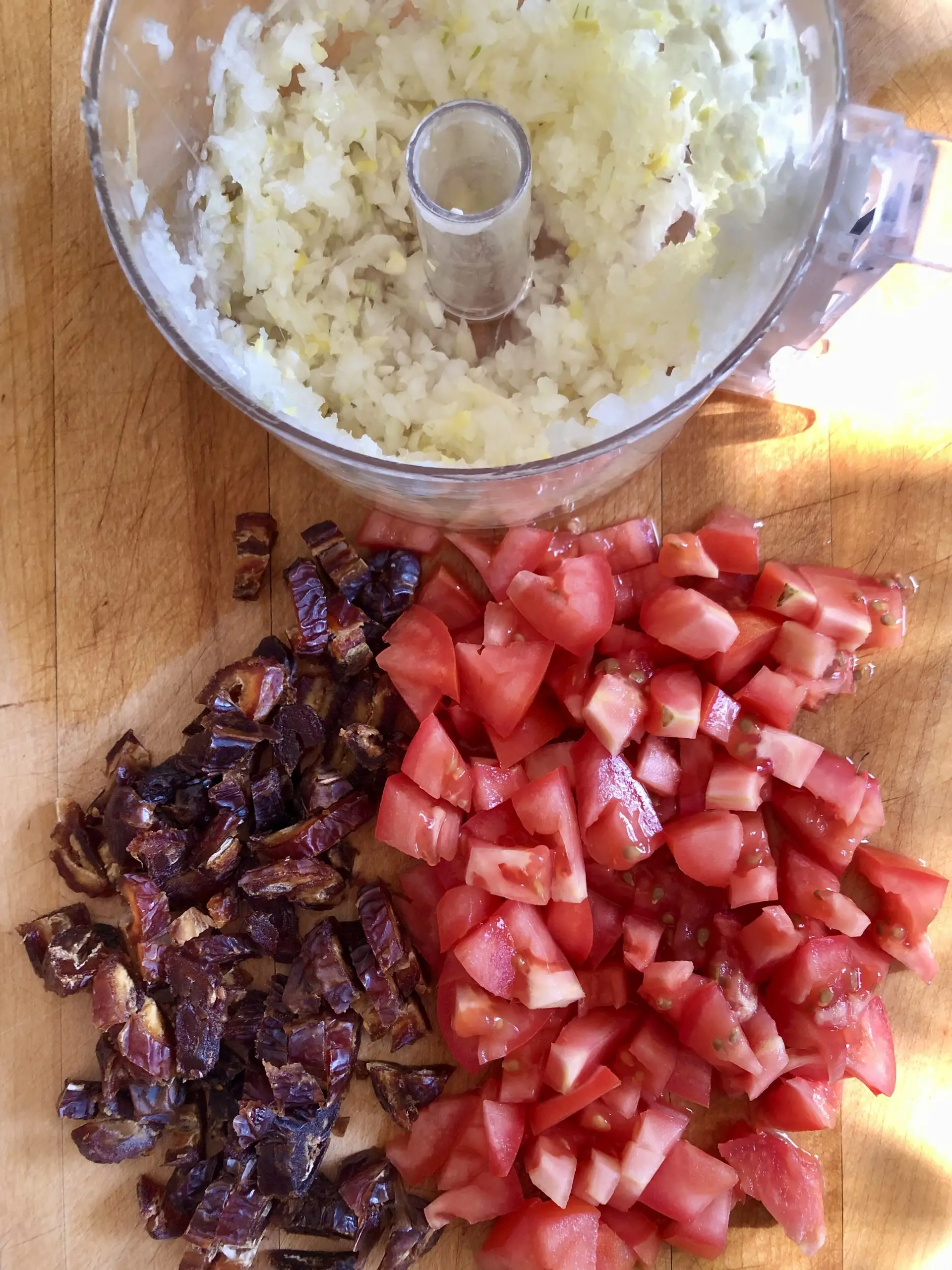 Minced onion, ginger and garlic in a food processor, diced tomatoes and dates