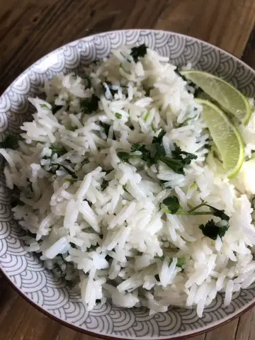 Cilantro Lime Rice in a bowl with slices of lime