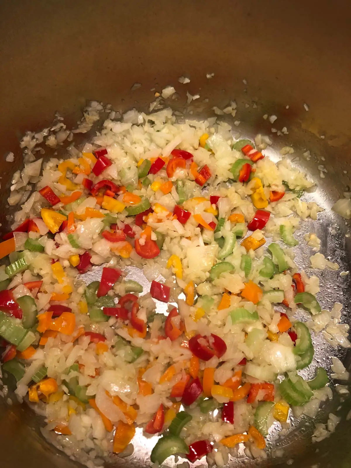 Diced onion, garlic, sweet bell peppers and celery in a large pot.