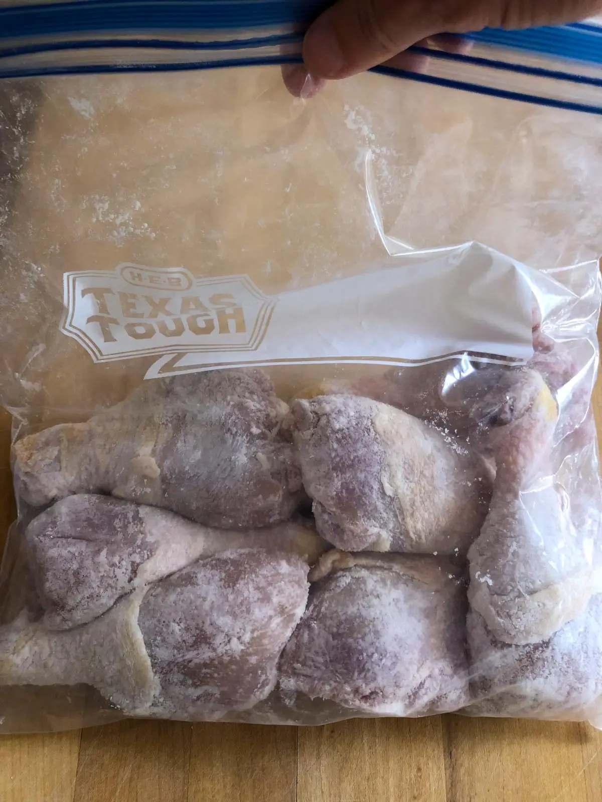 Chicken drumsticks covered with baking powder in a plastic zip bag.