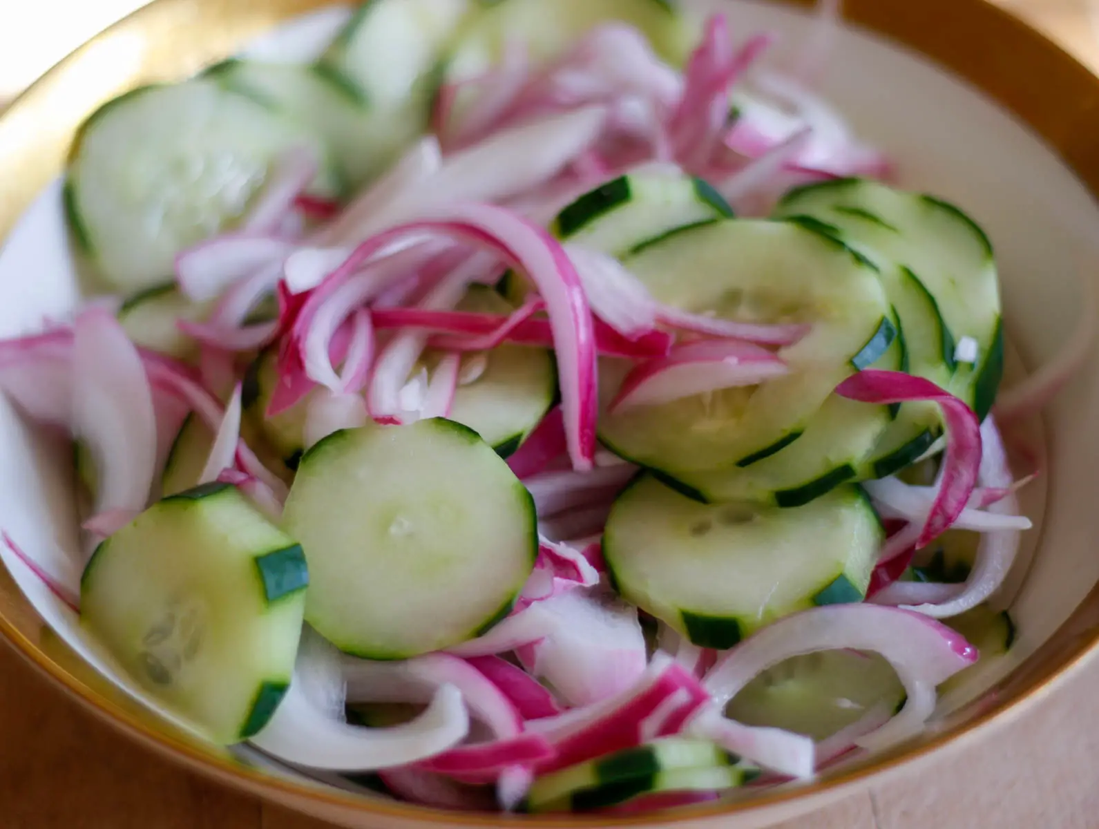 Southern Cucumber Salad in a gold rimmed bowl