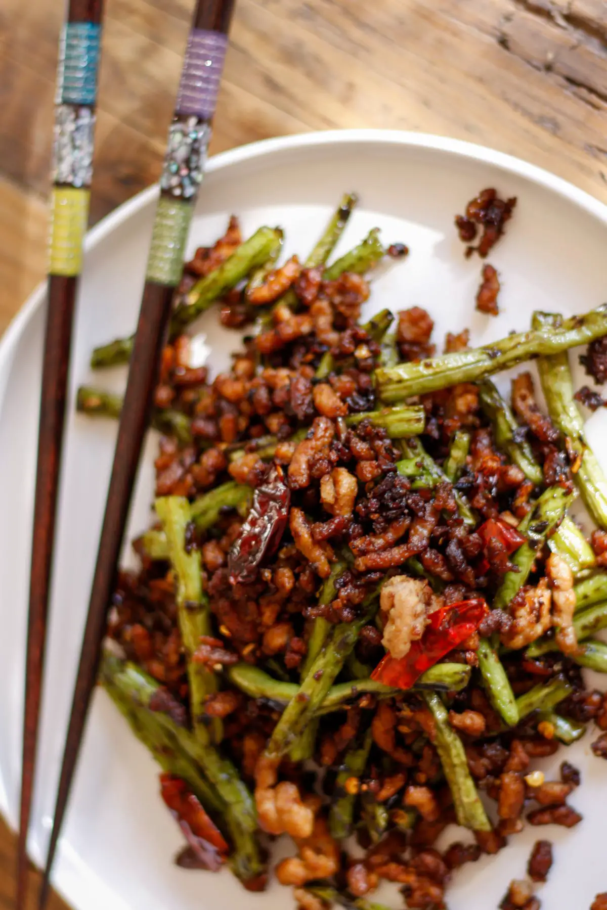 Chinese Long Beans With Pork on a white plate with chopsticks.
