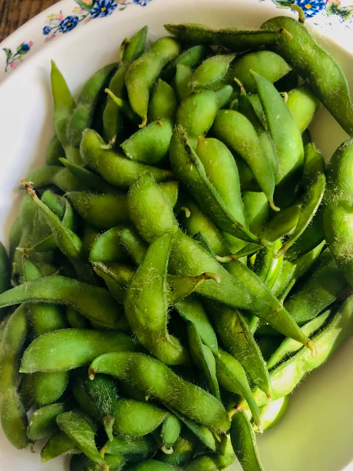 Edamame in their pods in a white bowl