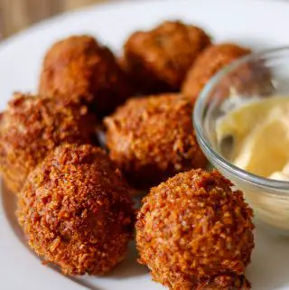 Boudin Balls on a white plate with mayo in a glass bowl
