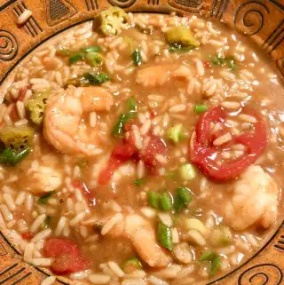 Shrimp gumbo with stewed tomatoes, pickled okra, and green onions as garnish.