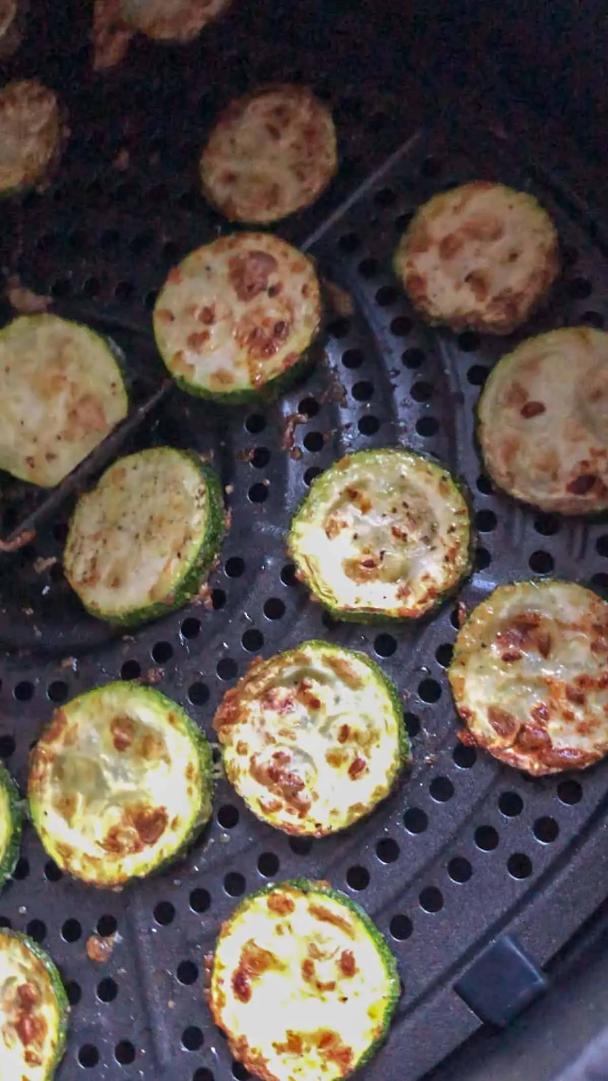 Roasted zucchini disks in an air fryer basket