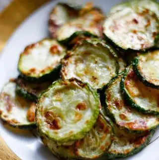 Zucchini disks which have been roasted with browned cheese on top.