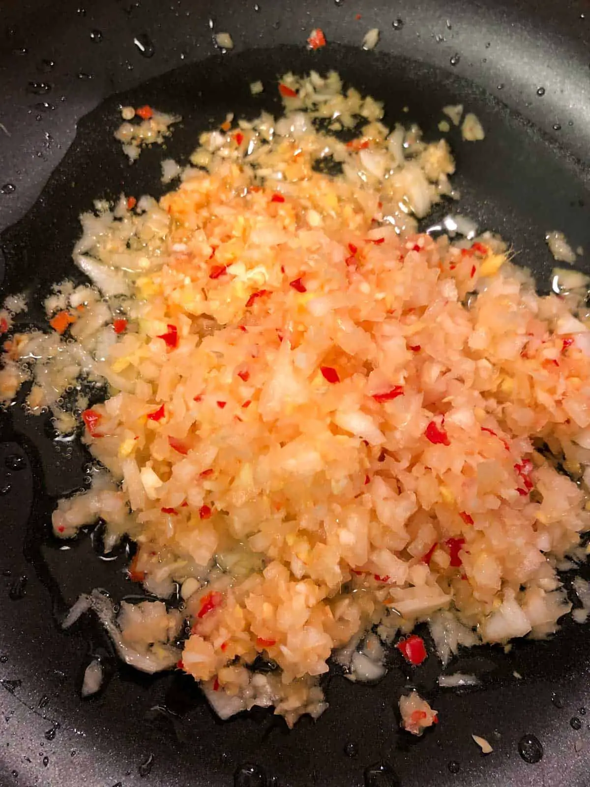 Minced onion, garlic, chilies, and ginger in oil in a large skillet.