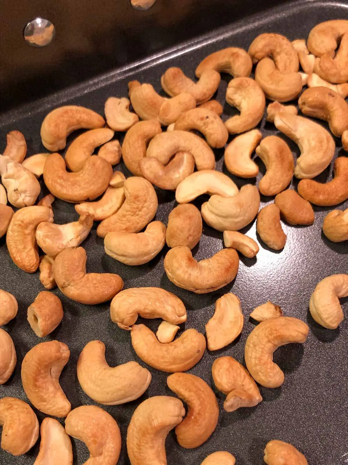 Roasted cashews in a roasting tray.
