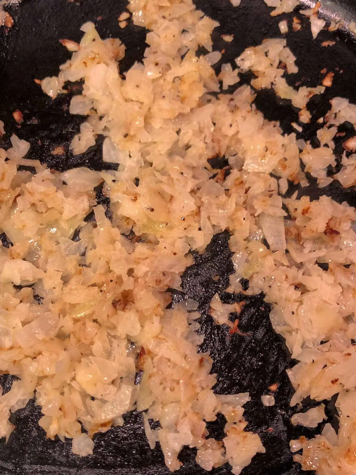Diced onion which as been browned in a cast iron skillet.