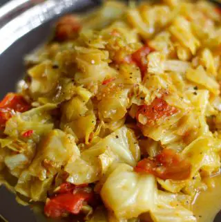 Indian spiced cabbage with tomato and seasonings on a silver plate.