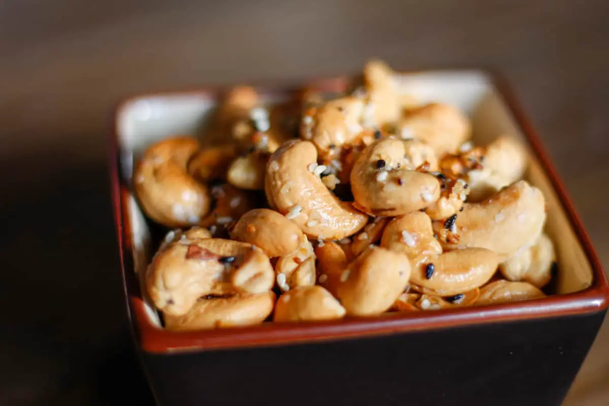 Cashews seasoned with Everything Bagel seasoning in a square brown dish.