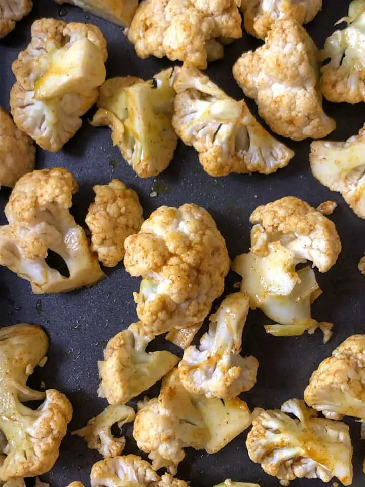 Cauliflower florets coated with olive oil and spices.