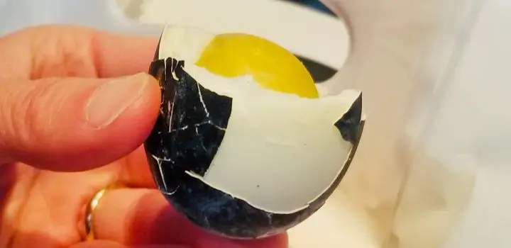 A Hakone Black Egg which has been peeled and you can see the inside white and yellow yolk of the egg. 