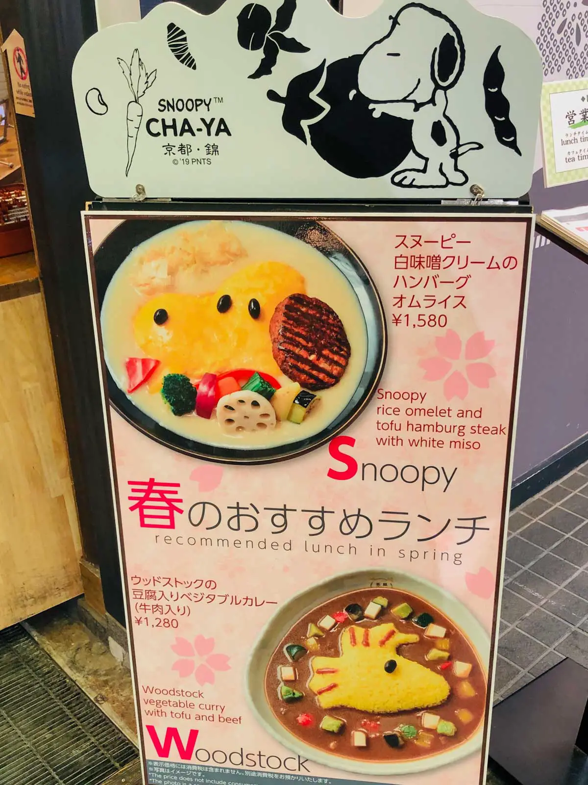 A sign for Snoopy Cha-Ya Restaurant with pictures of a snoopy rice omelet and a Woodstock curry.