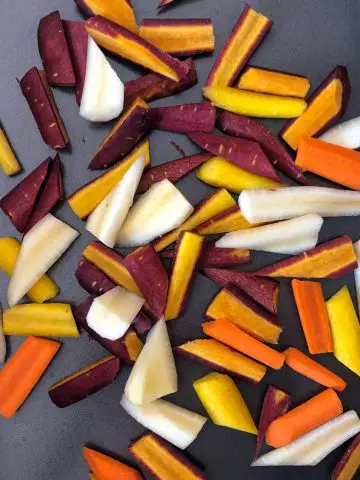 Slices of multicolored carrots in a roasting tin.