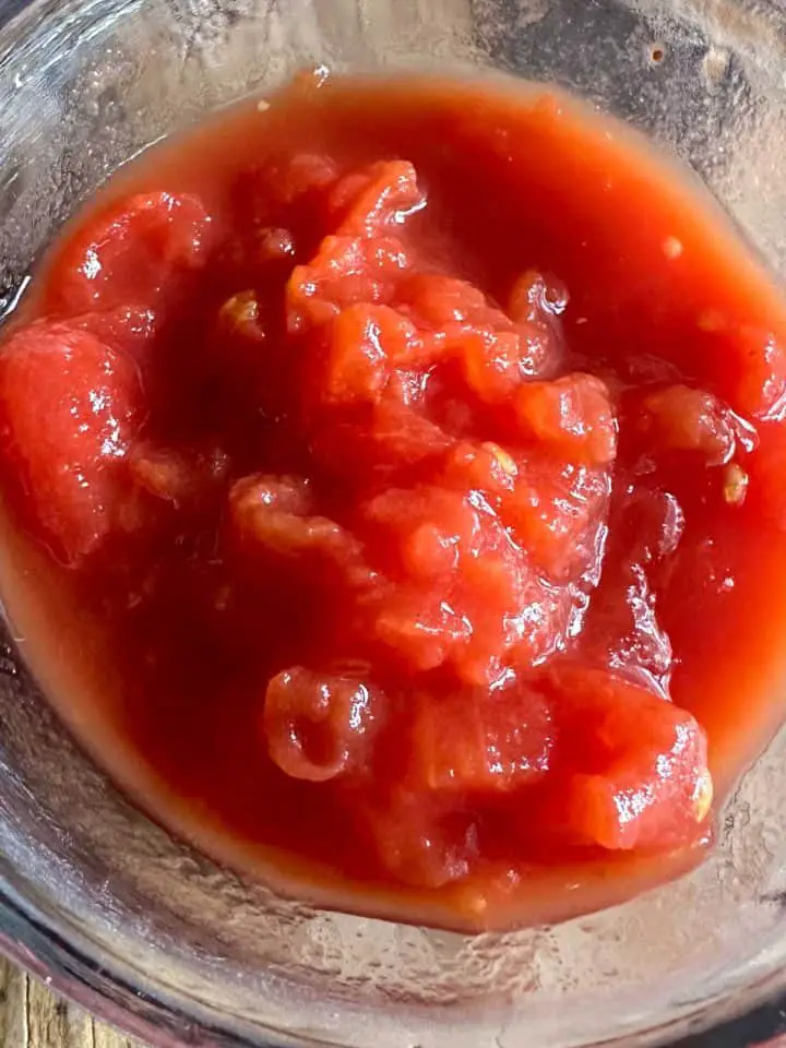 Tomatoes and tomato sauce in a glass bowl.