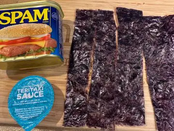 A can of Spam, slices of nori, and a container of Teriyaki sauce.