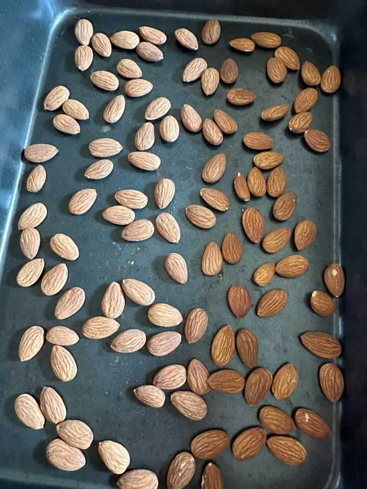 Raw almonds in a roasting tin.