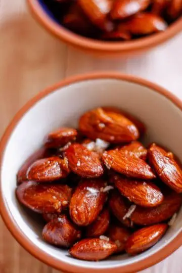Small bowls filled with roasted almonds garnished with sea salt flakes.