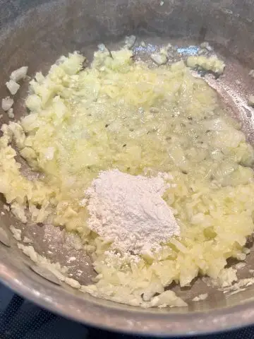 Minced onion and garlic with flour in a saucepan.