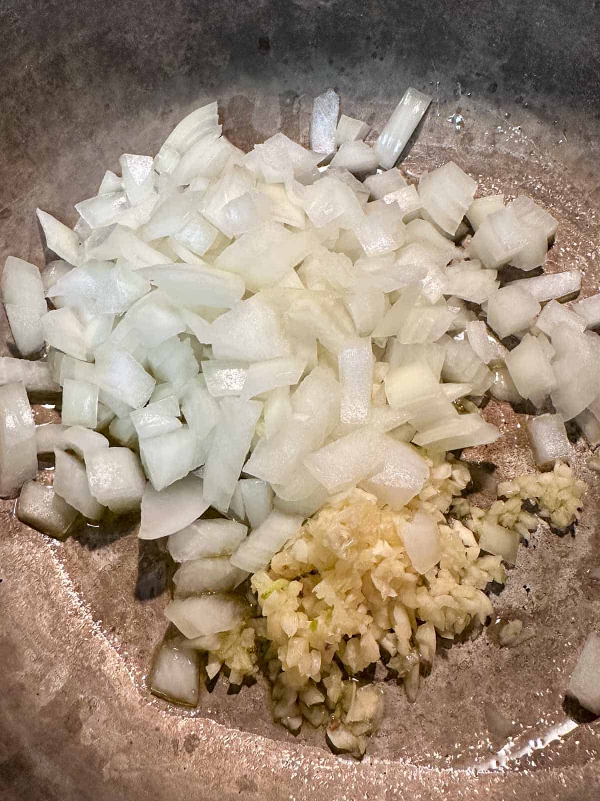 Chopped onion and minced garlic in a saucepan.