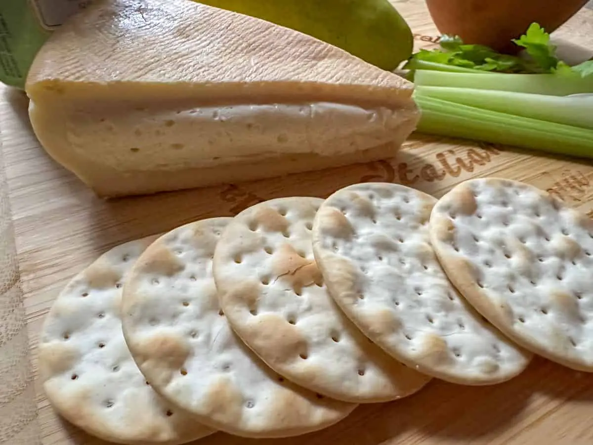Stinking Bishop cheese, water crackers and celery on a cheeseboard.