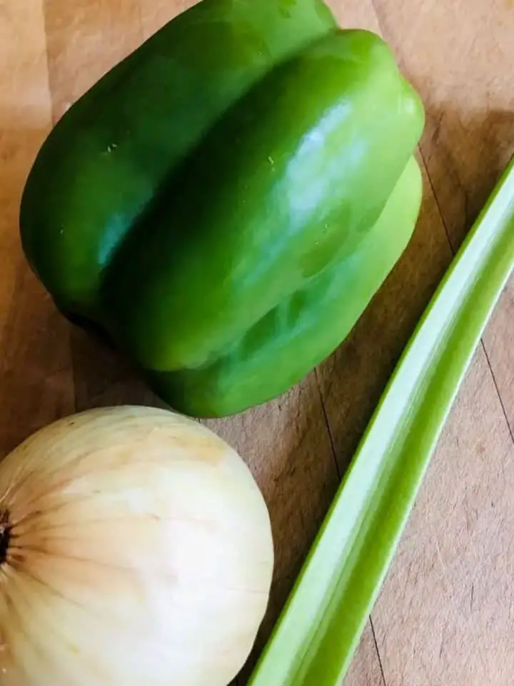 A green bell pepper, an onion, and stalk of celery.