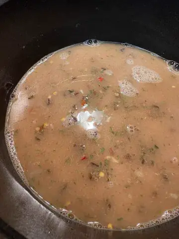 Gumbo mix with spices dissolved in water in a large pot.