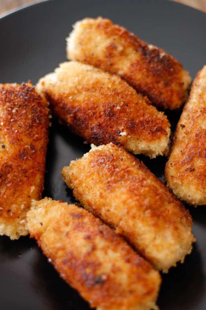 Several golden brown ground chicken cutlets displayed on a plate.