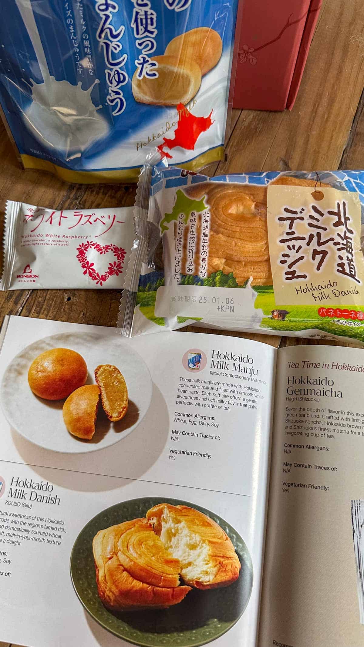 A selection of Japanese snacks and an opened Sakuraco Snack Guide.