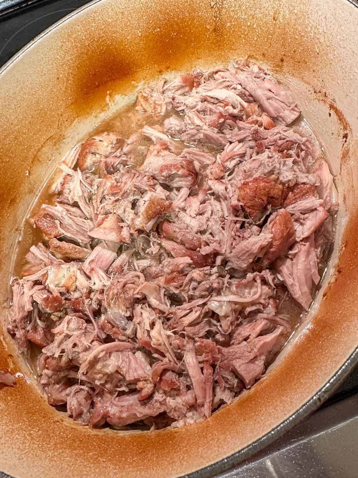 Shredded pork in a Dutch oven.