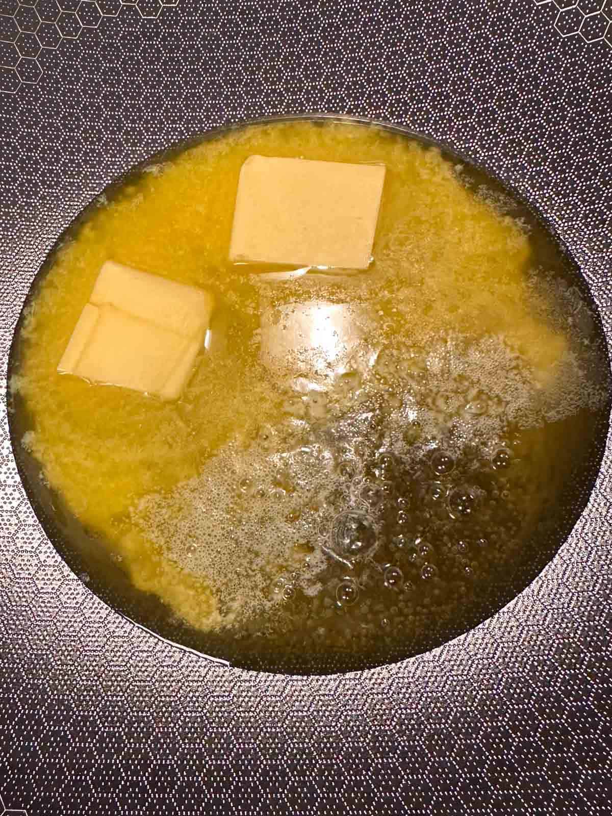 Melting butter in a wok.