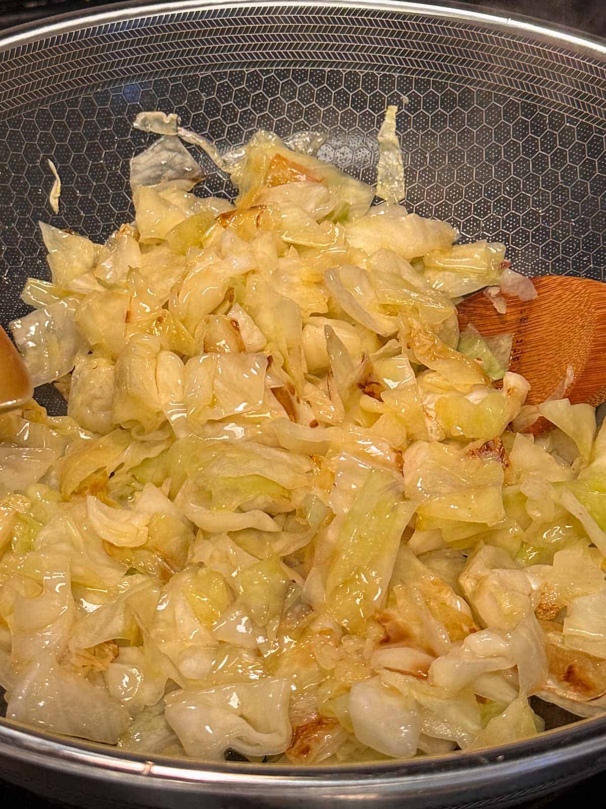 Sautéed chopped cabbage in a wok.